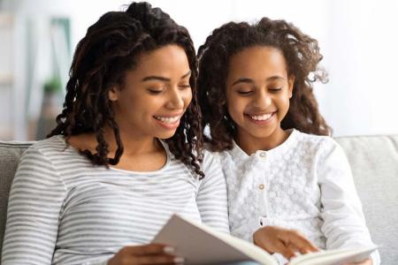 Mother and daughter reading together. (Prostock-studio /Adobe Stock)